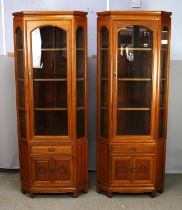 A pair of Chinese hardwood standing corner cupboards, in two parts, upper sections glazed,