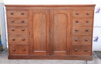 A mid Victorian mahogany housekeeper's cupboard, the pair of doors revealing four sliding trays and