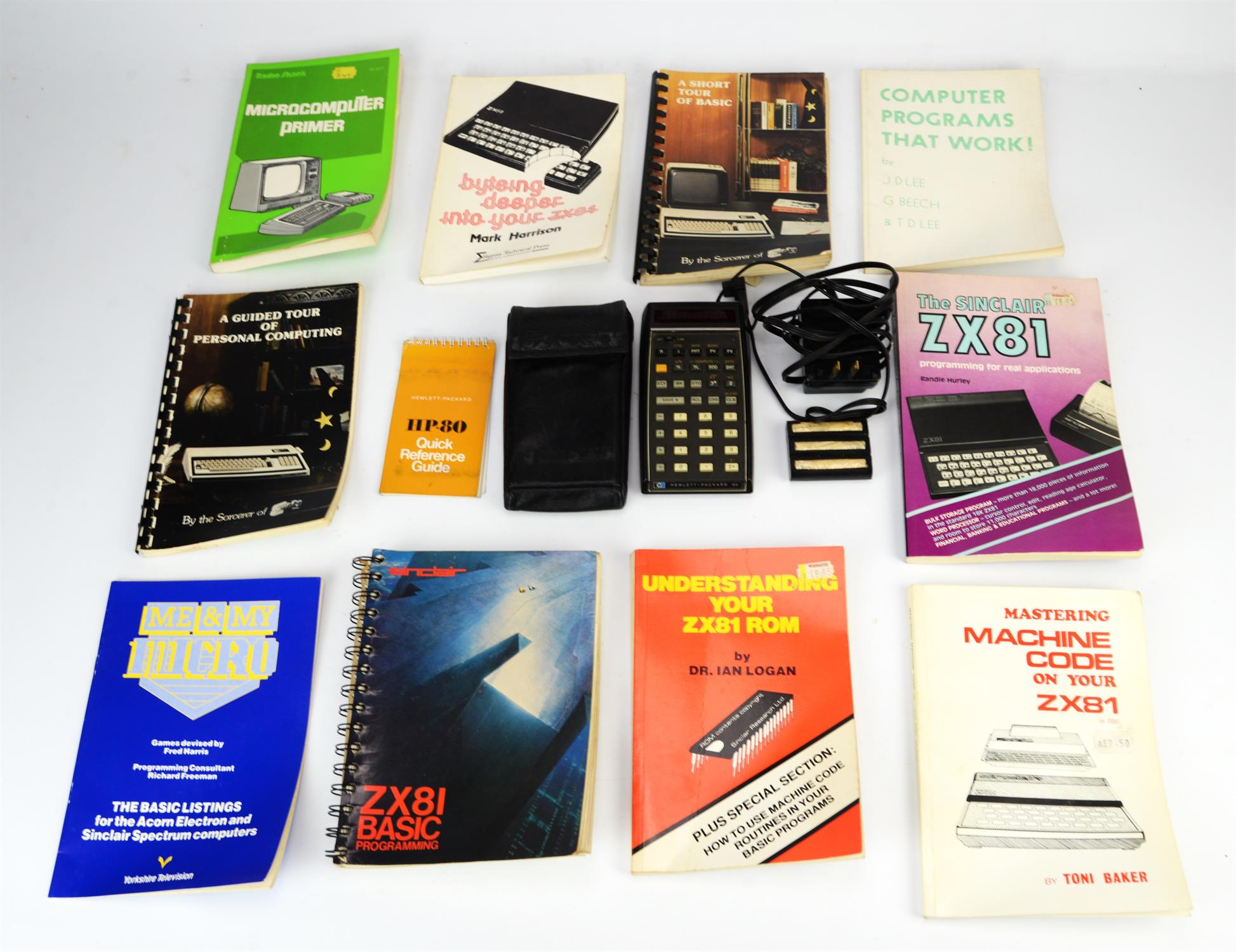 A Hewlett Packard HP-80 calculator and an assortment of vintage computing instruction manuals