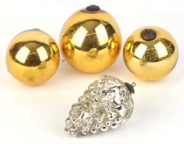 Four Edwardian glass baubles/witches balls, to include three gold examples and a silver coloured