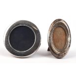 Two silver photo frames, one of oval form one in round form