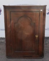 Oak corner cabinet, 18th Century and later, with dentil moulded cornice, above panelled door,