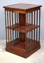 An Edwardian style mahogany revolving bookcase, of typical form and with a flame veneered section