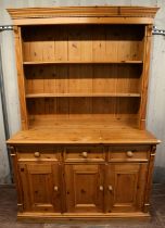 A Victorian style pine dresser, the cornice above two shelves enclosed by fluted terminals,