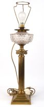 An Edwardian brass table lamp, 1st quarter 20th century, the cut glass oil reservoir on a