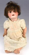 A German Heubach Koppelsdorf doll, with a biscuit porcelain painted head and composition limbs,