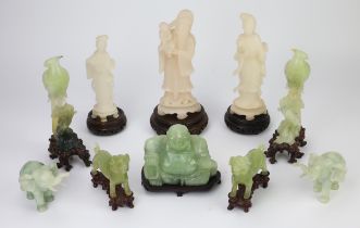 Collection of green hardstone and soapstone carved figure, most with carved wood stands,