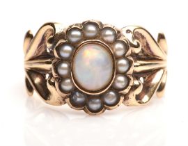 Opal and pearl ring, central oval opal with a surround of seed pearls with foliate motif shoulders,