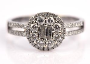 A diamond ring, set with two central baguette cut diamonds, with a double surround of round