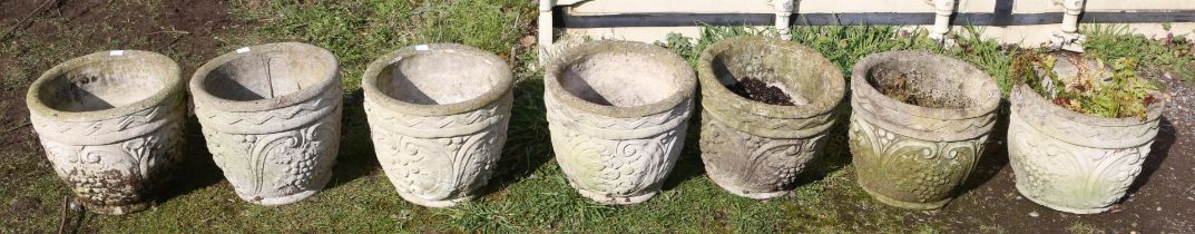 Seven reconstituted stone pots, moulded with grapes and scrolls, 28cm high x 32cm diameter (7)