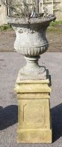 Reconstituted stone Campana urn, on rectangular plinth, the urn 51cm high, the plinth 61cm high