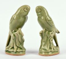 A pair of celadon Budgerigar, 19cm high; together with a framed and glazed Chinese textile