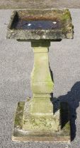 Reconstituted stone bird bath, with square dished top, on square baluster column, on stepped base,
