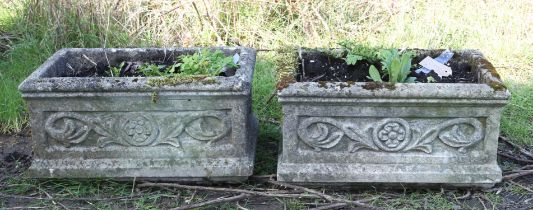 Pair of reconstituted stone rectangular planters, with flower and scroll decoration,