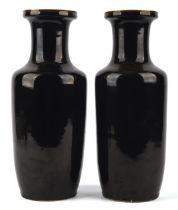 A pair of mirror-black or wujin, monochrome vases of rouleau form; both about 35.