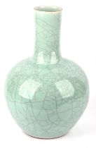 A large blue/green monochrome vase with cylindrical neck, decorated with irregular crackle designs;