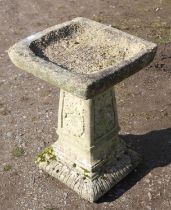 Reconstituted stone bird bath, with square dished top, on floral tapering column, with lobed base,