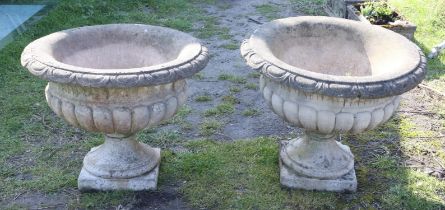 Pair of reconstituted stone garden urns, with lobed rims and bodies, on pedestal bases,