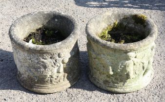 Pair of reconstituted stone cylindrical planters, moulded with cherubs, 26cm high x 30cm diameter