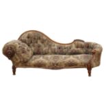 A Victorian walnut and upholstered chaise longue, the arm with a large leaf carved roundel, L 208cm