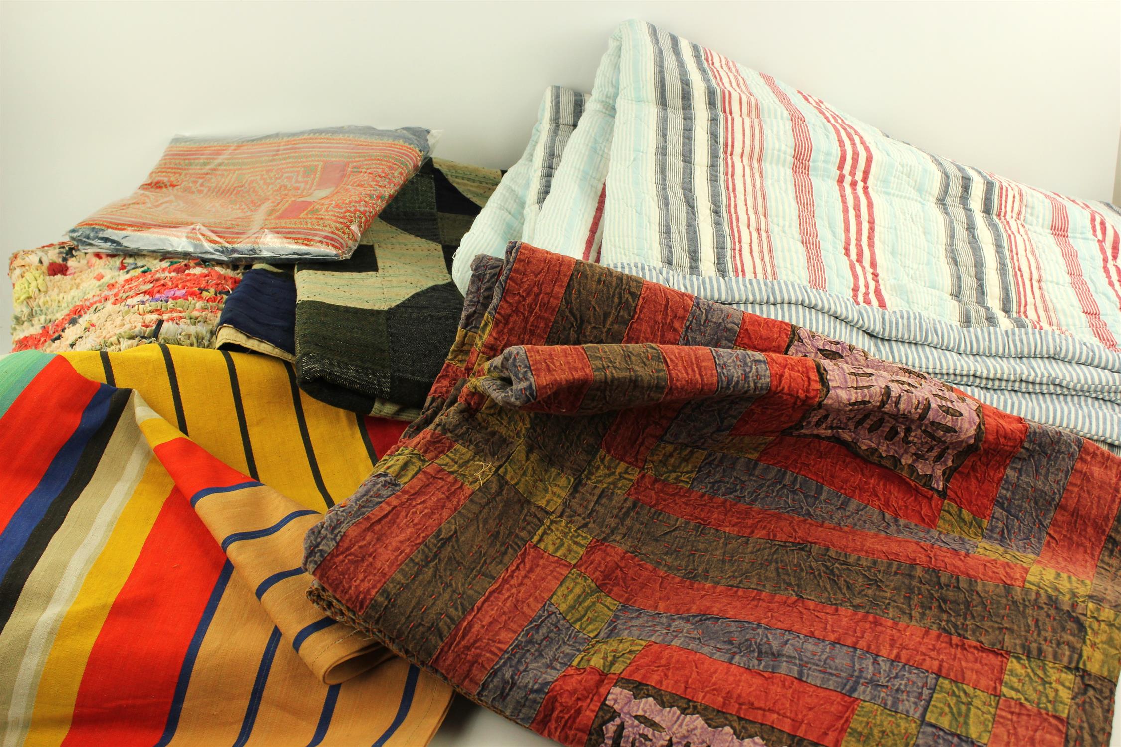 A box of various throws and bedcovers, 20th century, to include a patchwork throw,