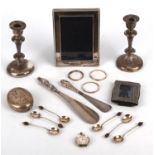 Quantity of mixed silver to include a pair of candlesticks, photo frames, tobacco squeeze box,