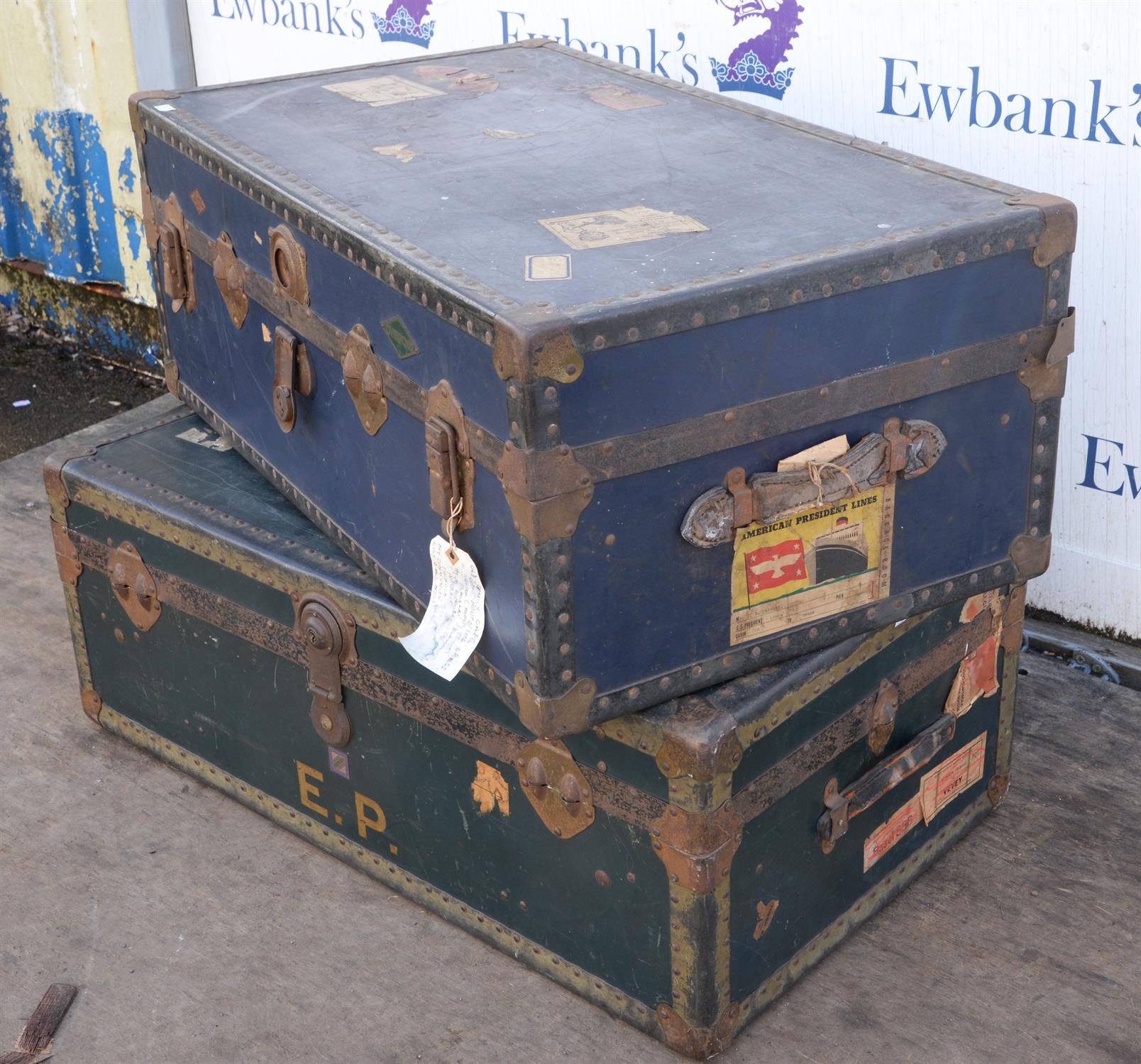 Matched pair of Steamer trunks, in green and red colourway, applied with shipping labels,