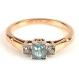Three stone blue zircon and diamond ring, with a central round cut blue zircon with an old single