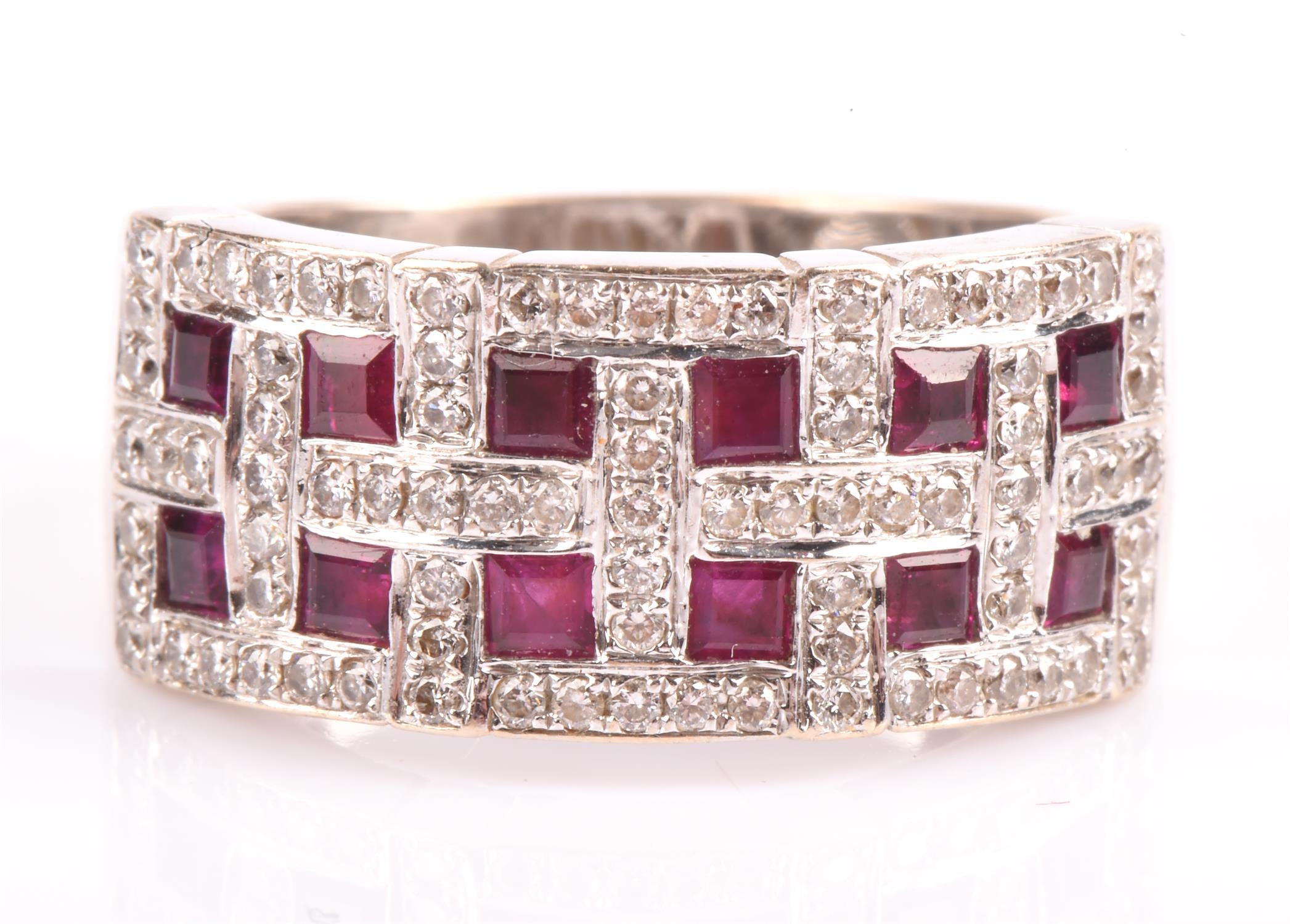 A ruby and diamond band ring, set with twelve square cut rubies, each surrounded by round brilliant