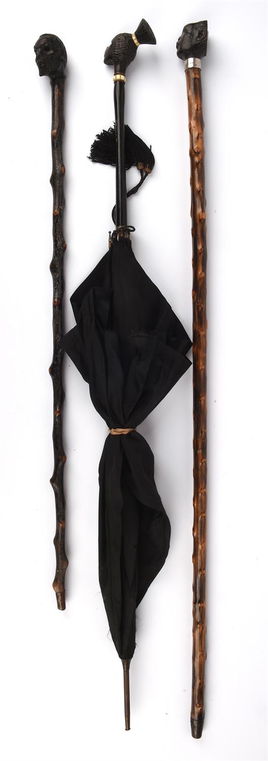 A hardwood parasol, 20th Century, with a finial carved in the form of an African native lady,