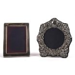 Two silver photo frames, the first embossed and with cherub decoration the second in plain form