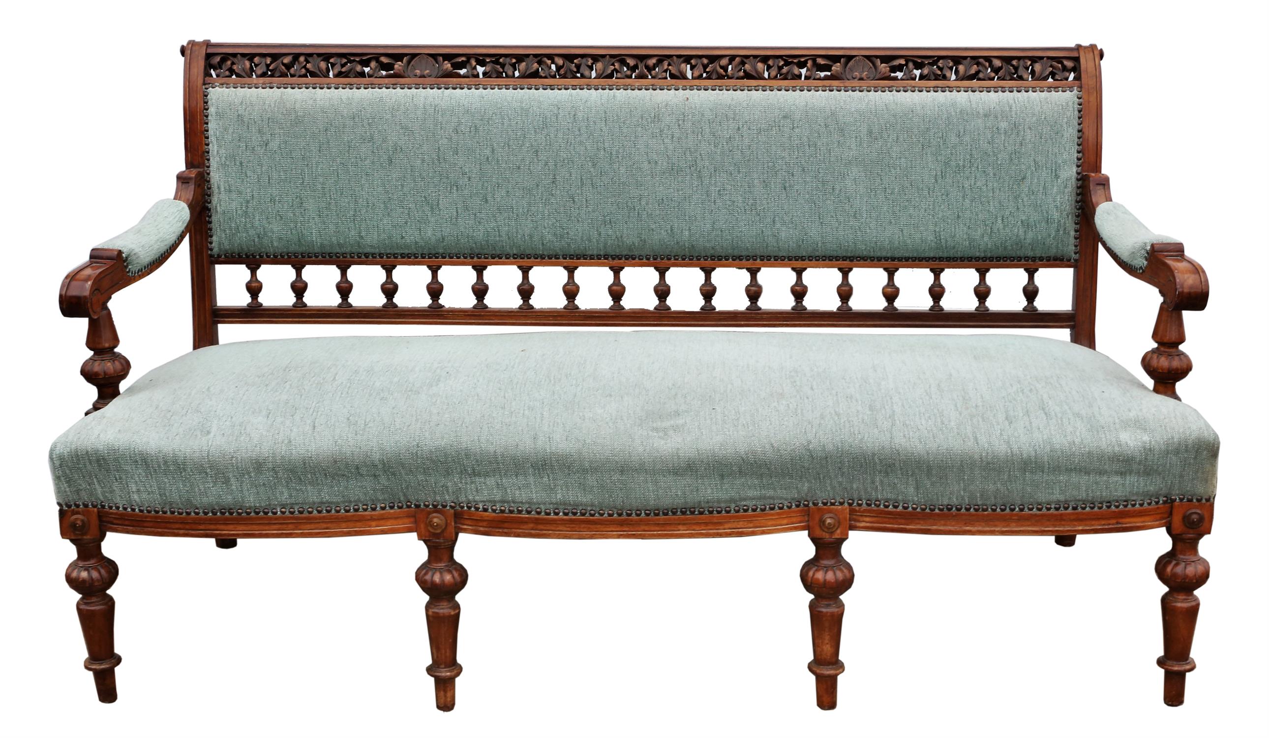 A late Victorian walnut and upholstered settee, the top rail pierced and leaf carved,