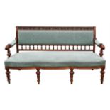 A late Victorian walnut and upholstered settee, the top rail pierced and leaf carved,