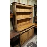 A Victorian pine dresser, in two parts, the shelved top above a base with two drawers and a pair of
