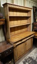 A Victorian pine dresser, in two parts, the shelved top above a base with two drawers and a pair of