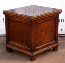 A George III oak box seat commode, of panelled form, the hinged lid revealing a removable seat,