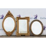 Three Gilt framed mirrors, two oval and one rectangular.