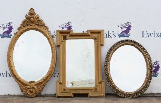 Three Gilt framed mirrors, two oval and one rectangular.