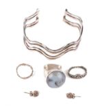 A selection of silver jewellery, including a cuff bangle, a gem set ring, a flower band ring,