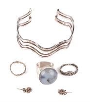 A selection of silver jewellery, including a cuff bangle, a gem set ring, a flower band ring,