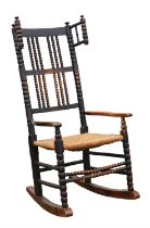 Manner of Ernest Gimson (British, 1864-1912), a stained ash rocking/nursing chair,