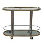 Unknown Designer, a chromed metal bar trolley, with glass top, above mirrored base, on casters,