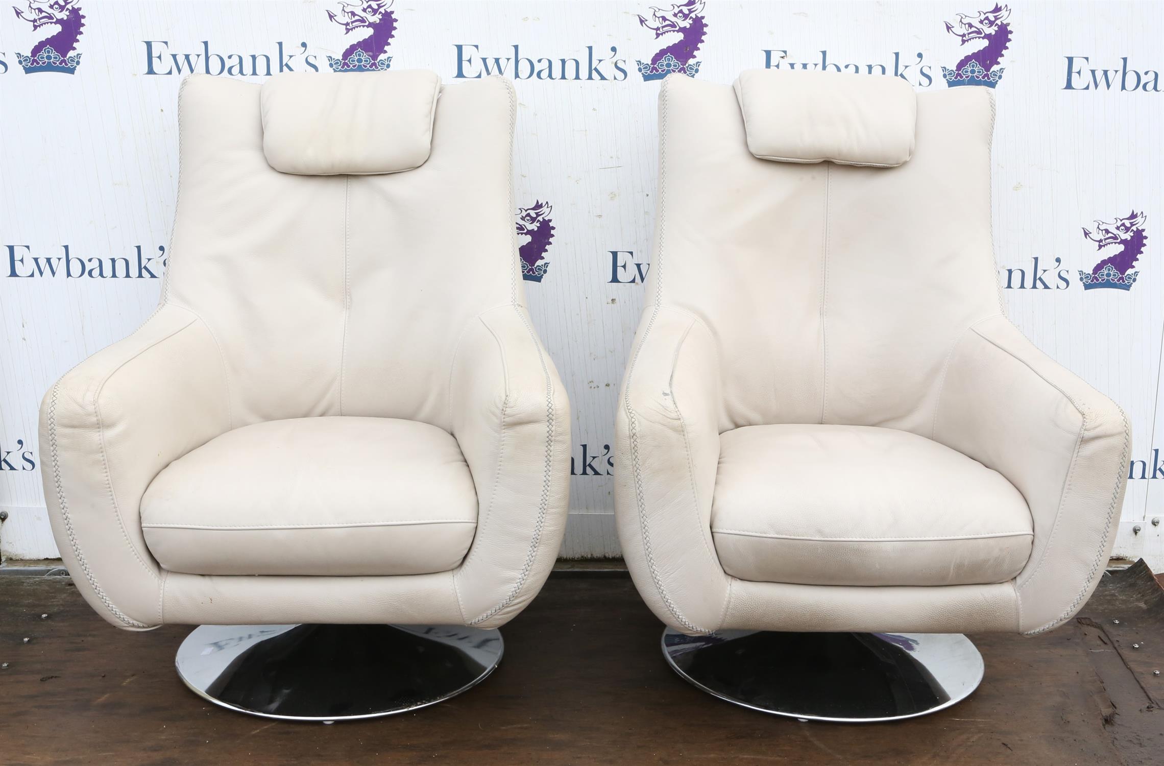 Unknown Designer, pair of cream leather upholstered swivel armchairs, on chromed metal bases,