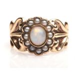 Opal and pearl ring, central oval opal with a surround of seed pearls with foliate motif shoulders,