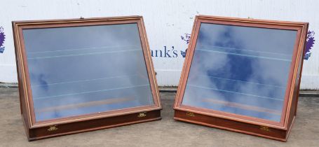 Two modern mahogany table display cabinets, of wedge shaped form, the moulded glazed panels opening