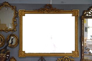 A 19th century style giltwood rectangular wall mirror with central carved crest detailed with a