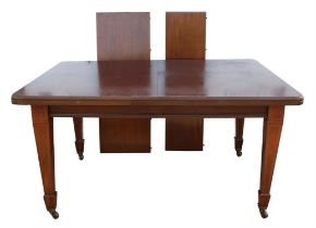 An Edwardian mahogany extending dining table, legs satinwood banded and with ceramic castors,