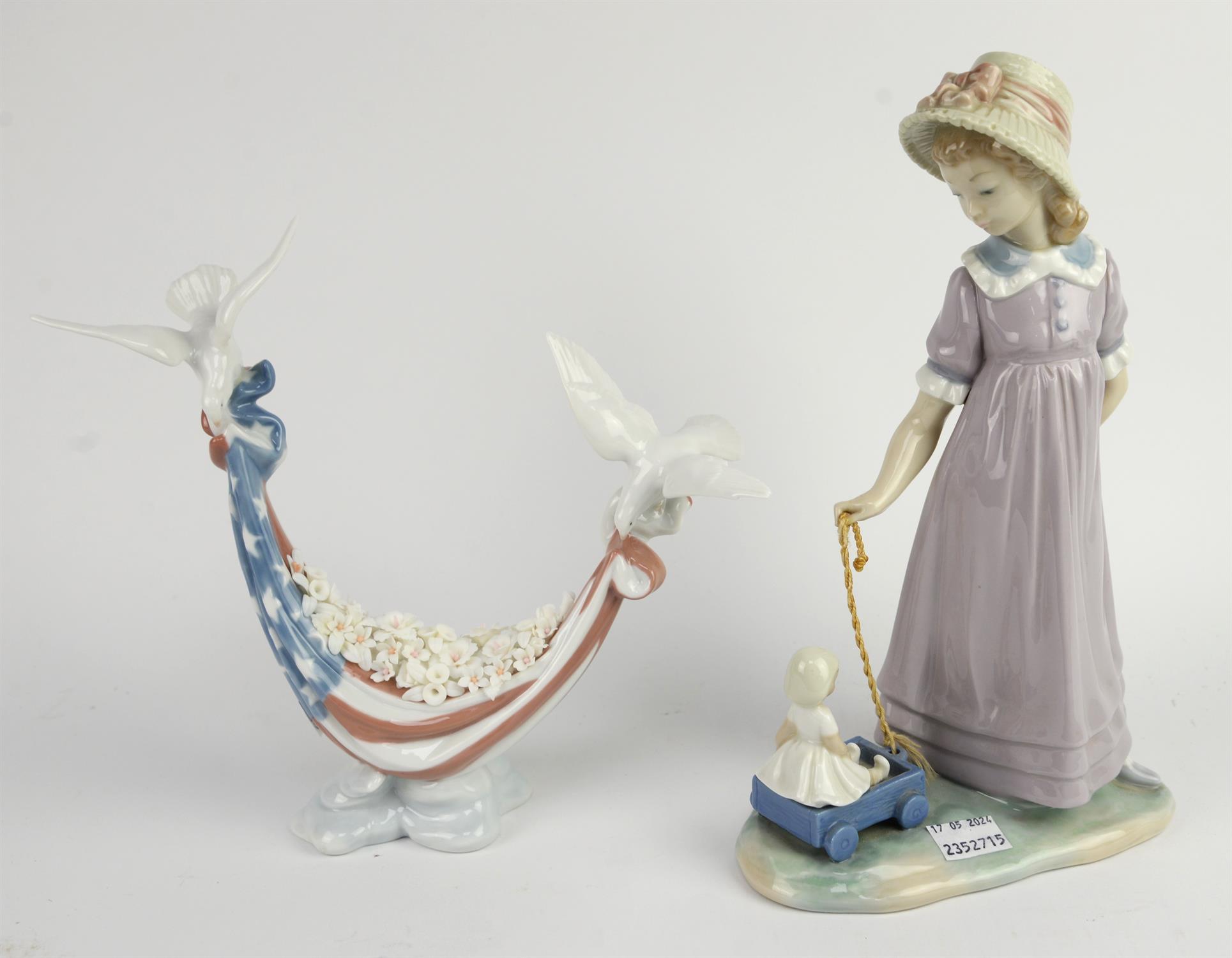 A Llladro porcelain figure depicting a young girl pulling a toy wagon, No 5044 and one further