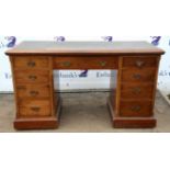 An Edwardian mahogany kneehole desk, adapted from a dressing table, with a tooled green leather