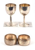 Pair of goblet form silver egg cups and a pair of 830 grade silver napkin rings